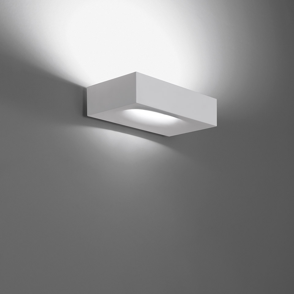 Artemide Melete wall lamp, white rectangular body, emitting upward and downward light beams against a grey wall