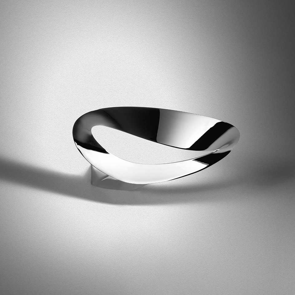 Artemide Mesmeri wall lamp with twisted chrome reflector diffusing soft light upward and downward on a white wall