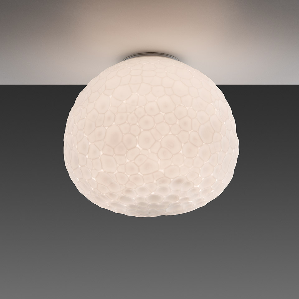 Artemide Meteorite ceiling lamp with white blown glass dome shade featuring organic cellular texture, mounted flush to ceiling