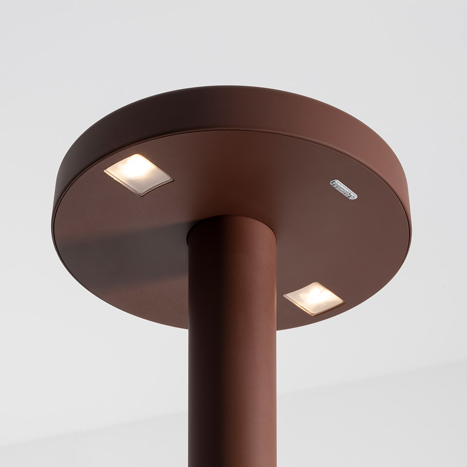Artemide Needoo floor lamp top view: round dark brown disc head with two recessed square LED lights on a cylindrical stem