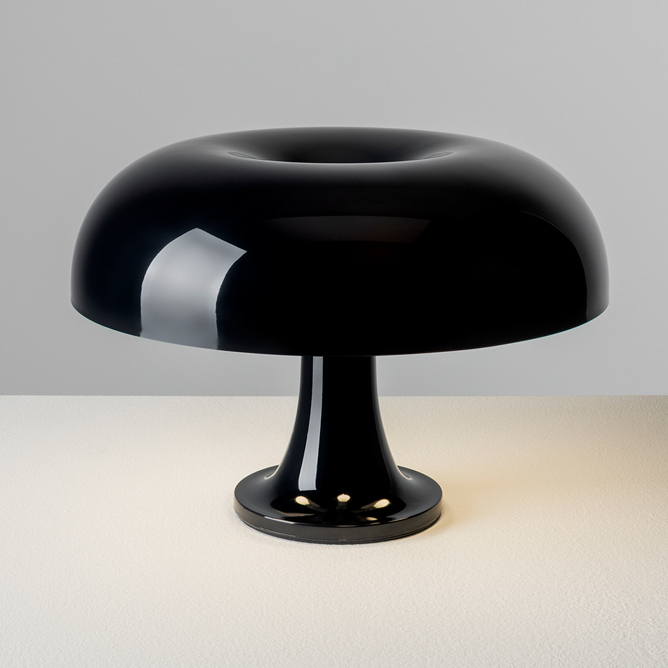Artemide Nessino table lamp in glossy black, featuring iconic mushroom-shaped shade on a trumpet base, casting warm light - 2