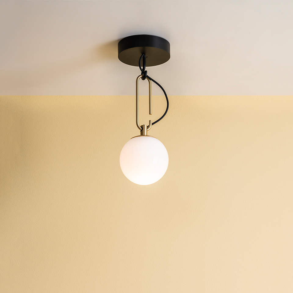 Artemide NH ceiling lamp with opal white glass globe shade, brass oval ring suspension, and black ceiling canopy
