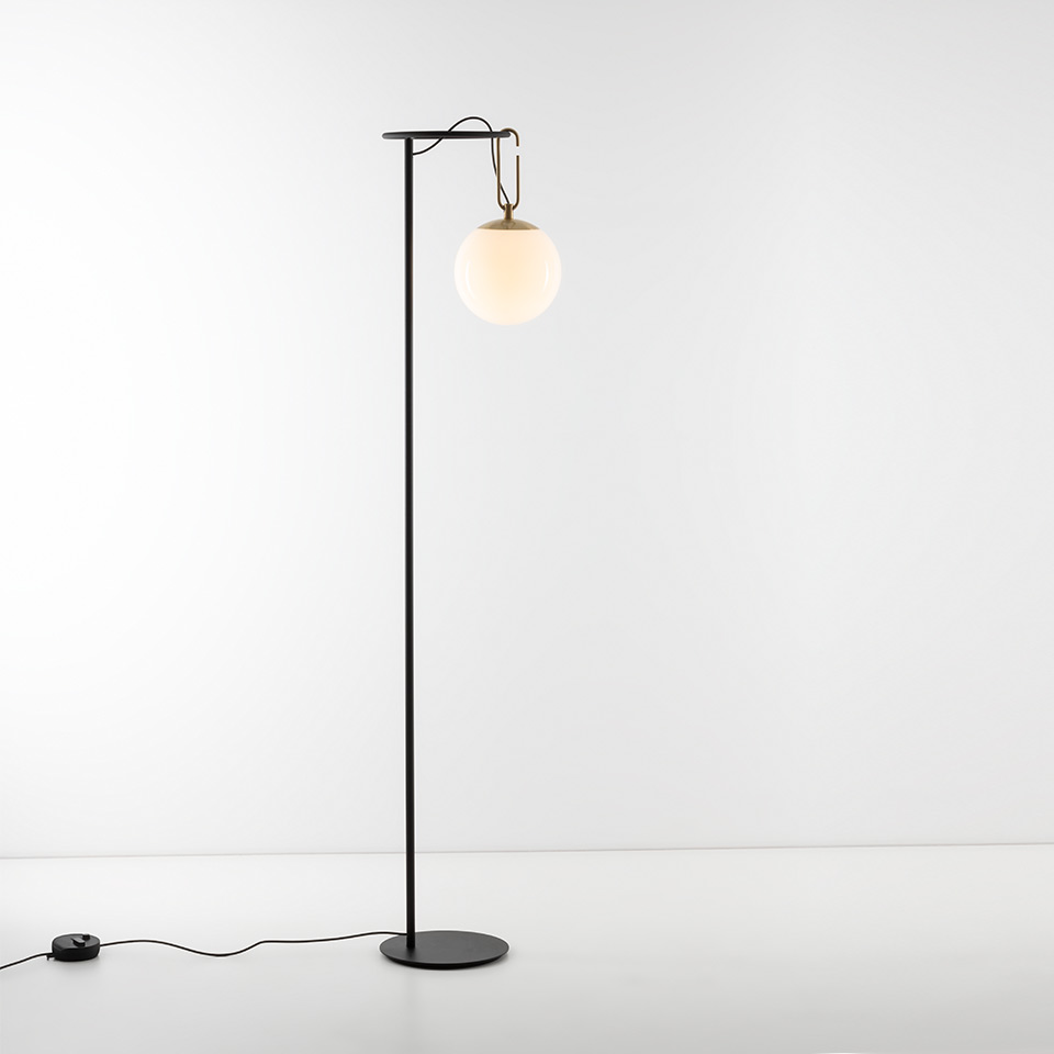 Artemide NH Terra floor lamp: tall black metal stem with round base, brass hook suspending an opal white glass globe shade