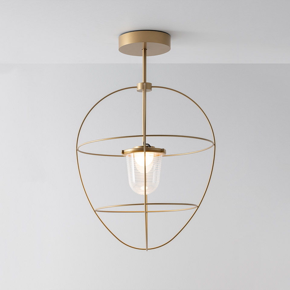 Artemide Nottola ceiling lamp: brushed gold oval metal frame with horizontal ring holding a ribbed glass diffuser
