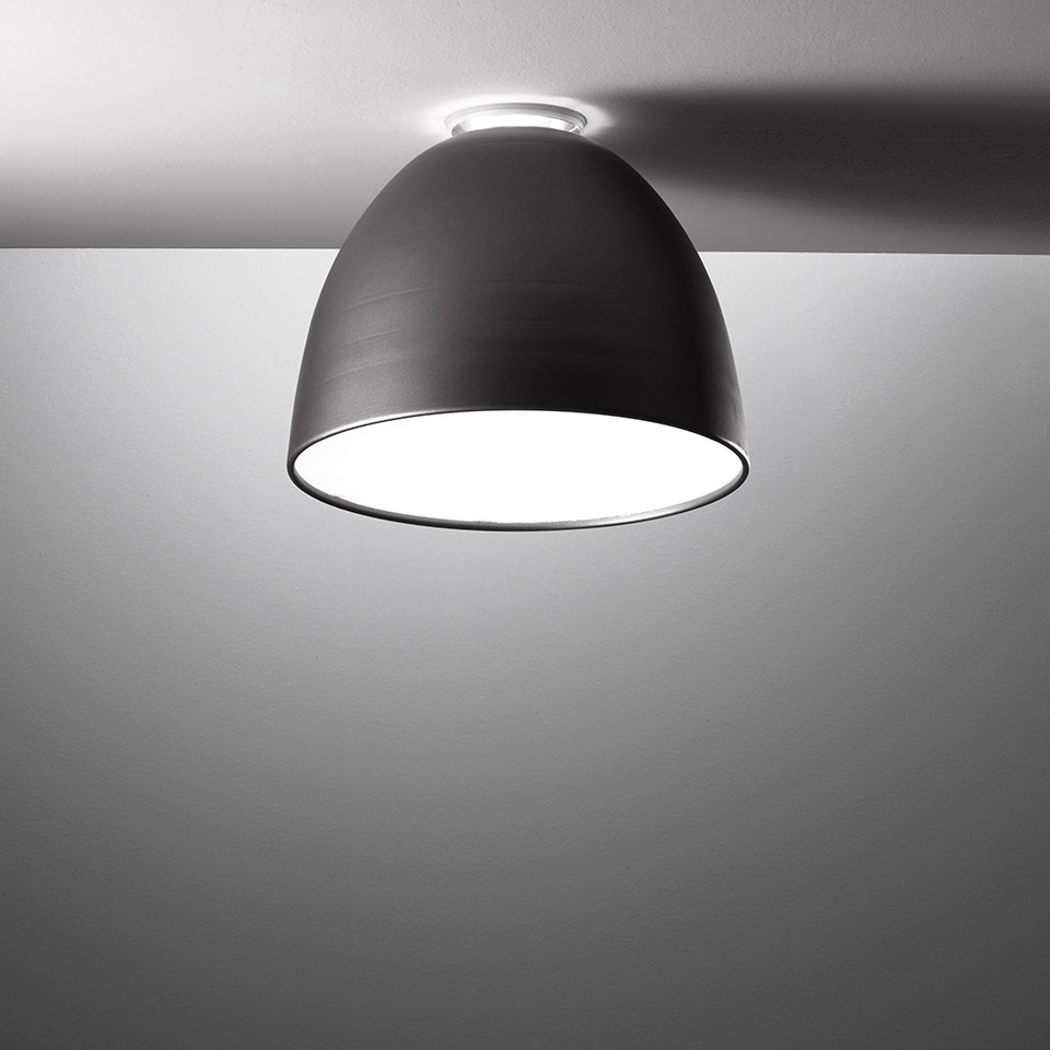 Artemide Nur Mini ceiling lamp with dark anthracite dome shade mounted flush to white ceiling, emitting downward light