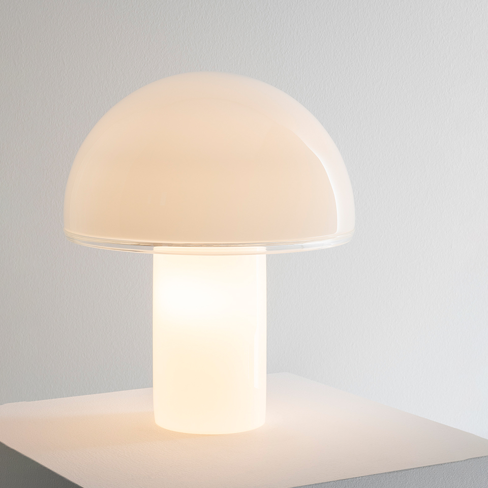 Artemide Onfale table lamp: mushroom-shaped opal white glass diffuser with cylindrical base, emitting warm soft light