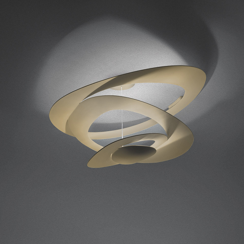 Artemide Pirce Soffitto ceiling lamp in gold, featuring sculptural spiral aluminum shade casting dramatic shadows on ceiling