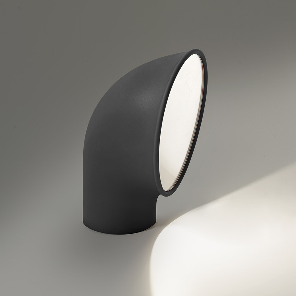 Artemide Piroscafo floor lamp: dark grey curved tubular body with angled diffuser, projecting warm white light downward