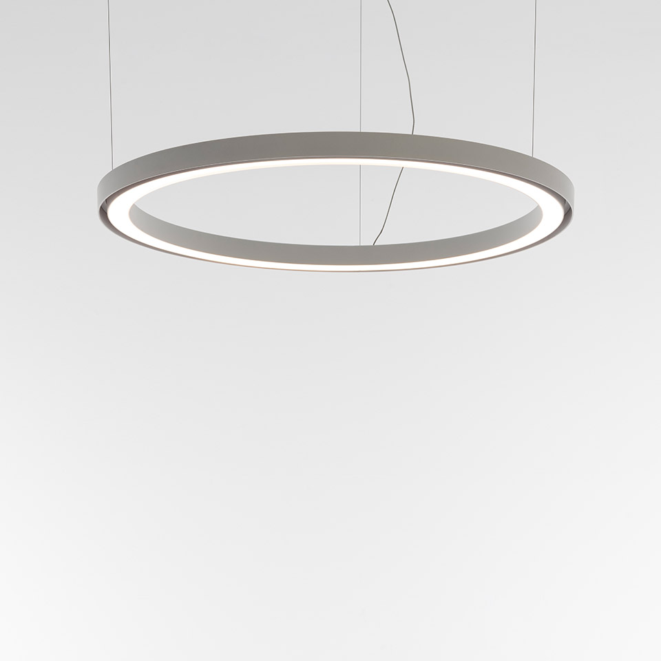 Artemide Ripple pendant lamp: large circular ring in grey with integrated LED strip emitting warm white light, suspended by thin cables
