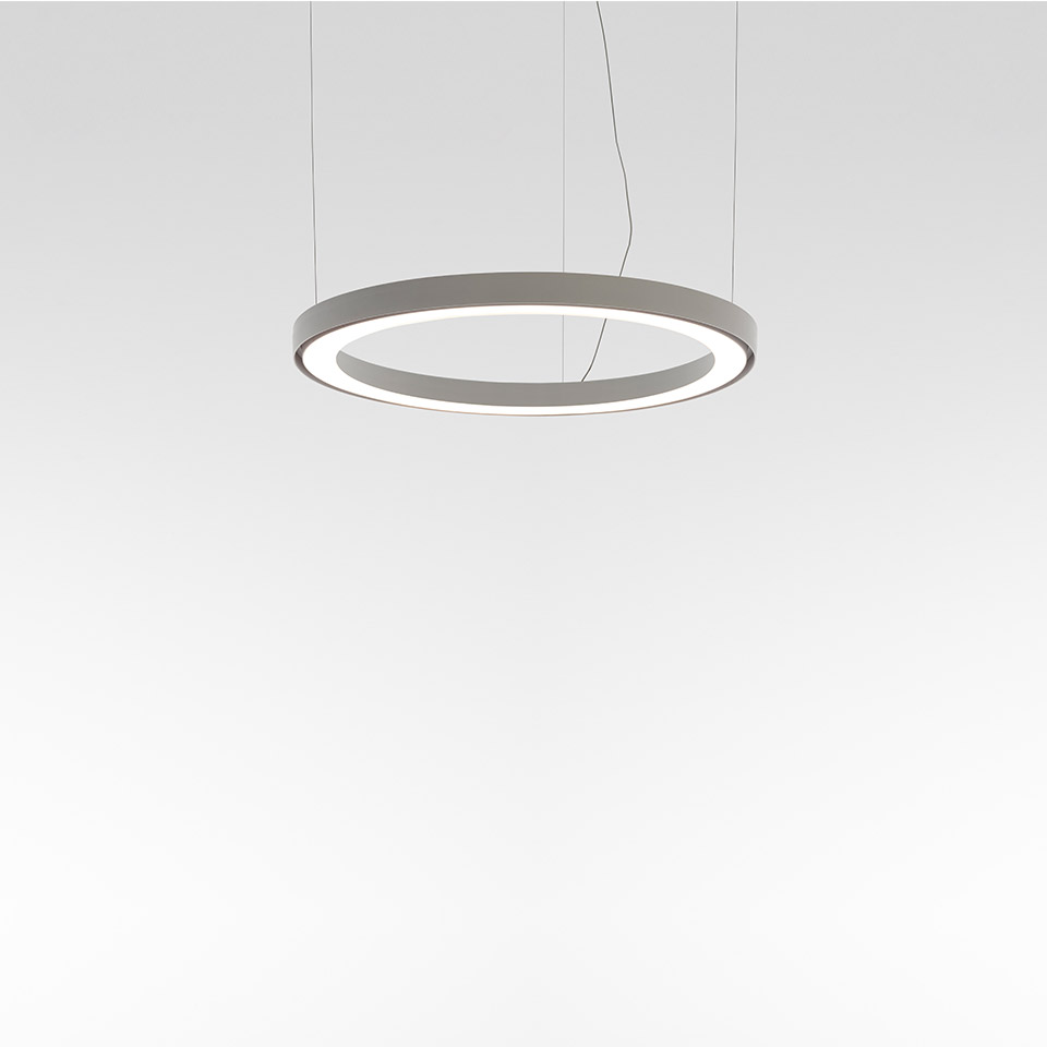 Artemide Ripple pendant lamp: circular ring-shaped LED fixture in grey, emitting soft diffused light from inner edge, suspended by thin cables