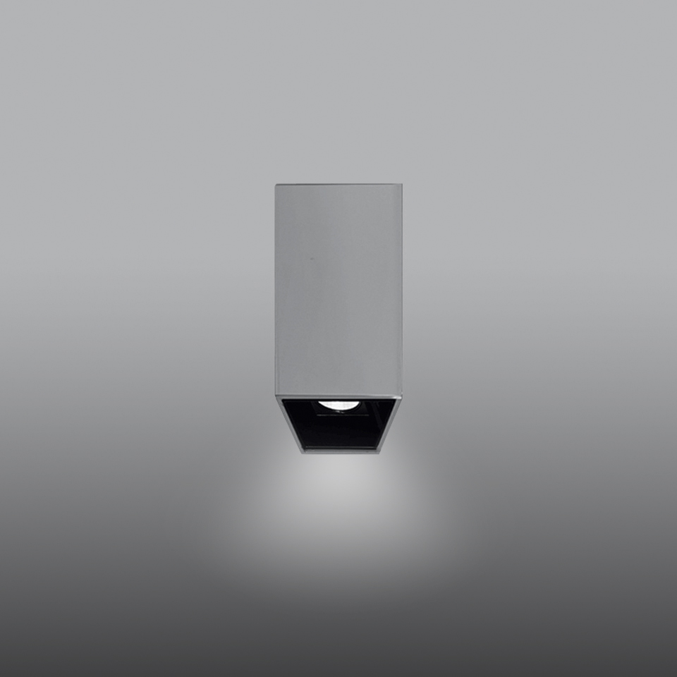 Artemide Sharp SMD ceiling spotlight: rectangular grey body with black recessed head emitting a focused downward beam of white light