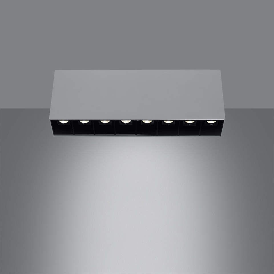 Artemide Sharp SMD ceiling light: rectangular white housing with 7 black recessed LED modules emitting focused downward beam