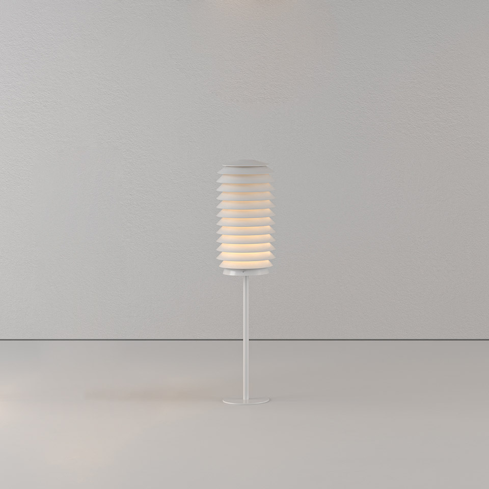 Artemide Slicing table lamp: white cylindrical shade with horizontal layered slats on a slender stem base, emitting warm diffused light