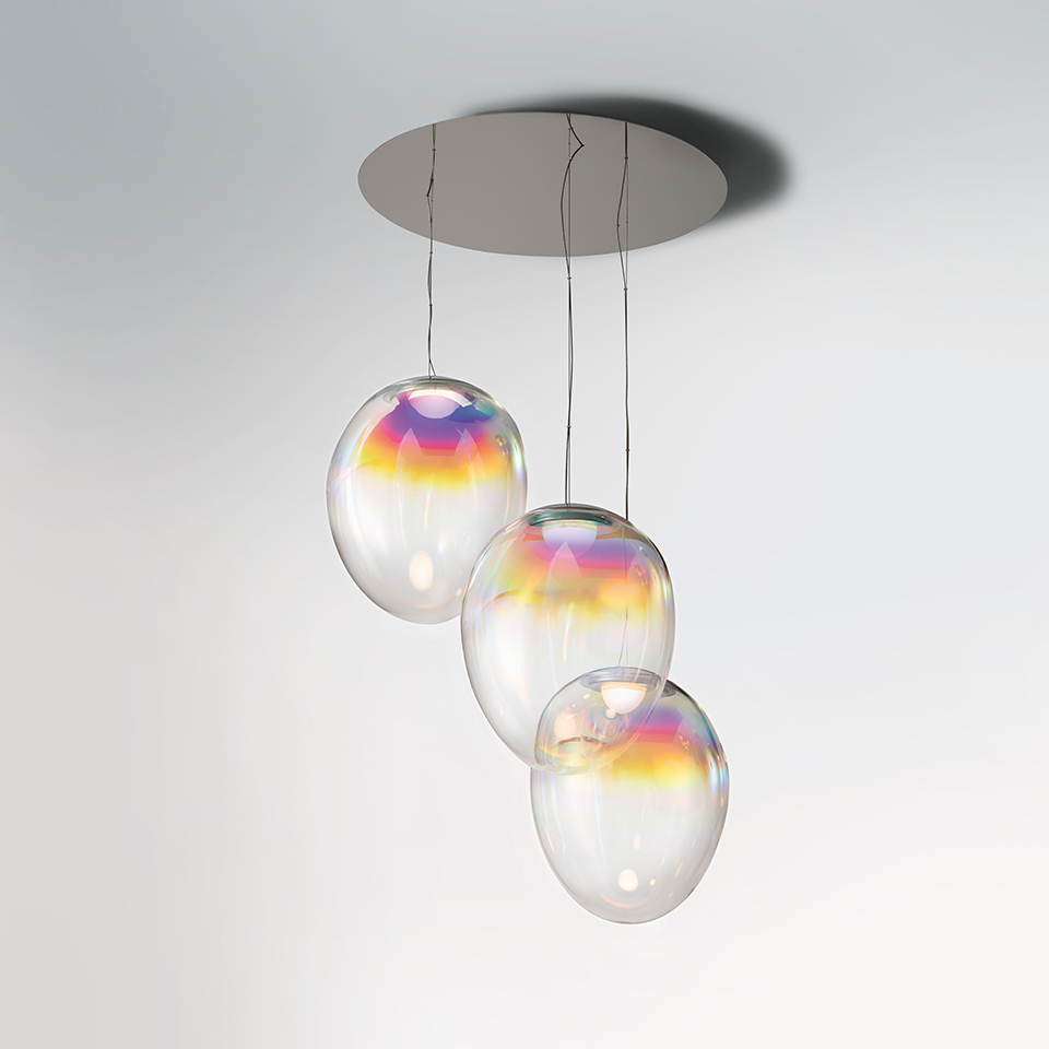 Artemide Stellar Nebula pendant: three iridescent oval glass globes with rainbow reflections, suspended at varying heights from a round ceiling plate