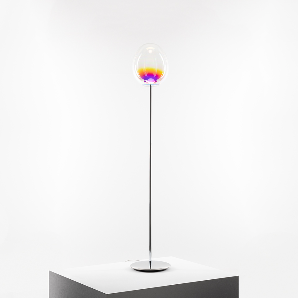 Artemide Stellar Nebula floor lamp: tall chrome stem, oval clear glass diffuser with vibrant yellow, orange, purple gradient light inside