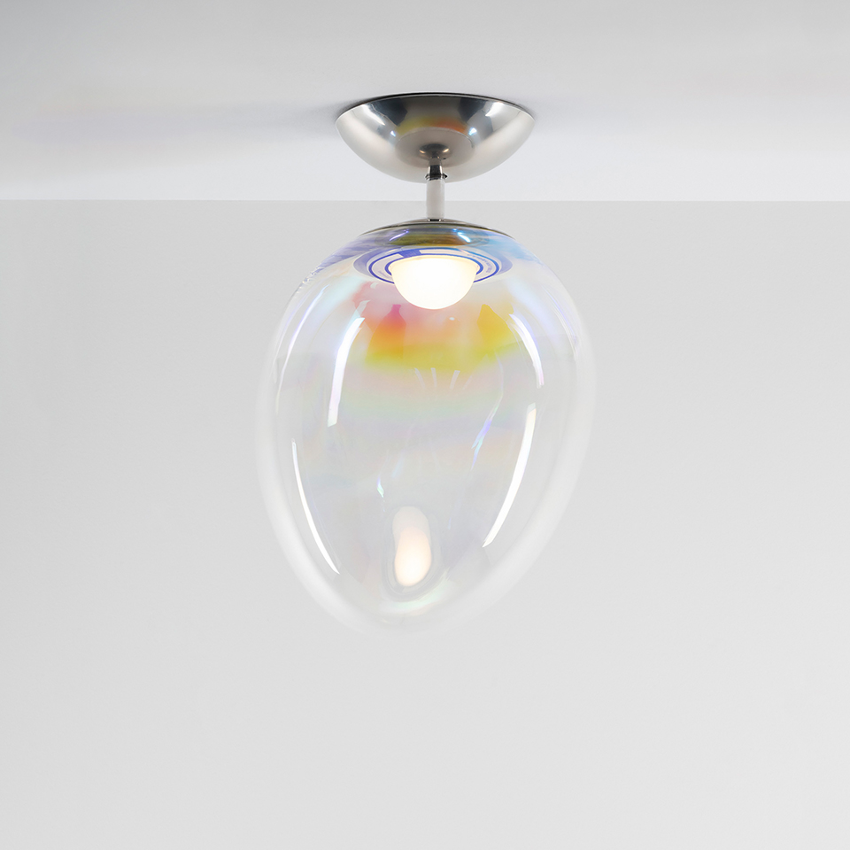 Artemide Stellar Nebula ceiling lamp with iridescent oval glass diffuser reflecting rainbow hues, mounted on a brushed nickel ceiling rose