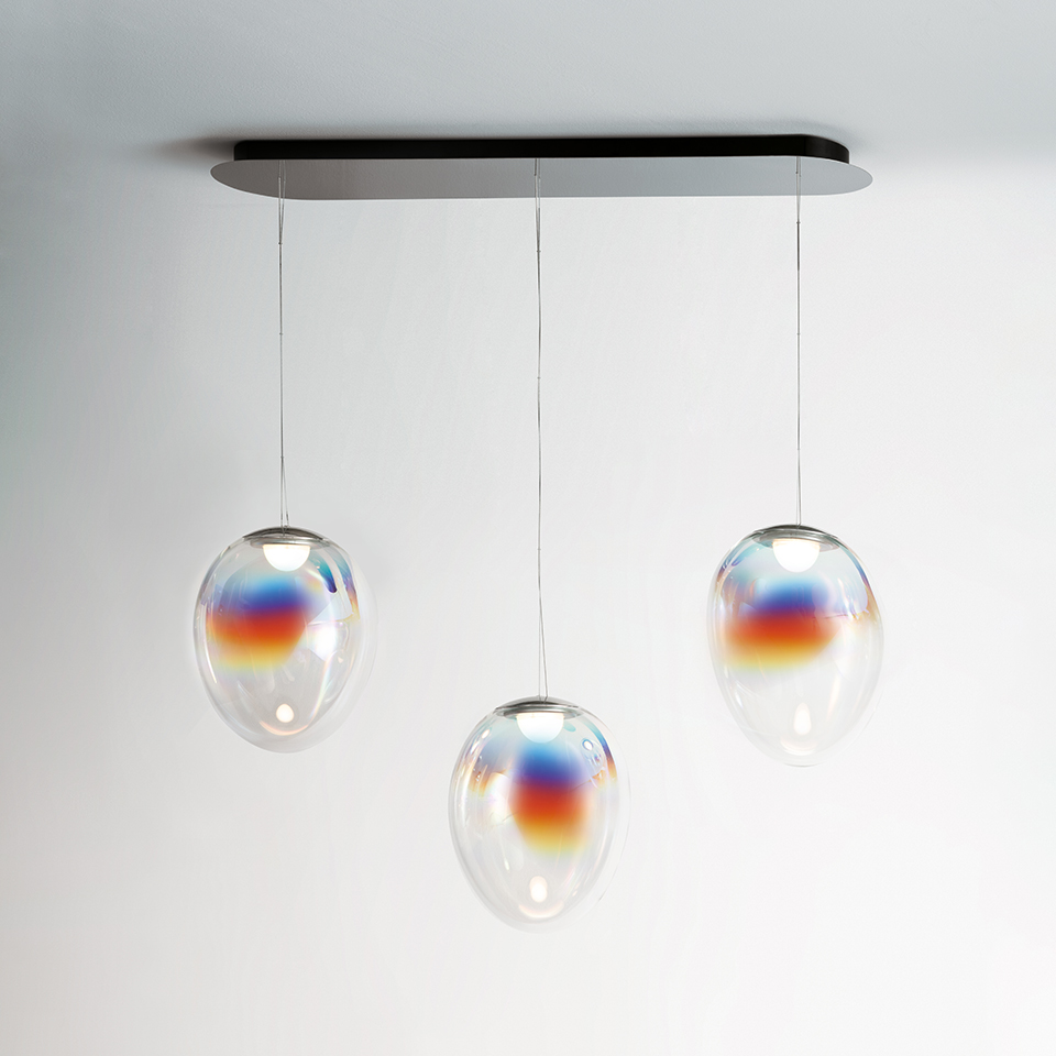 Artemide Stellar Nebula: three iridescent oval glass pendant lights with rainbow hues, suspended from an elongated black ceiling canopy