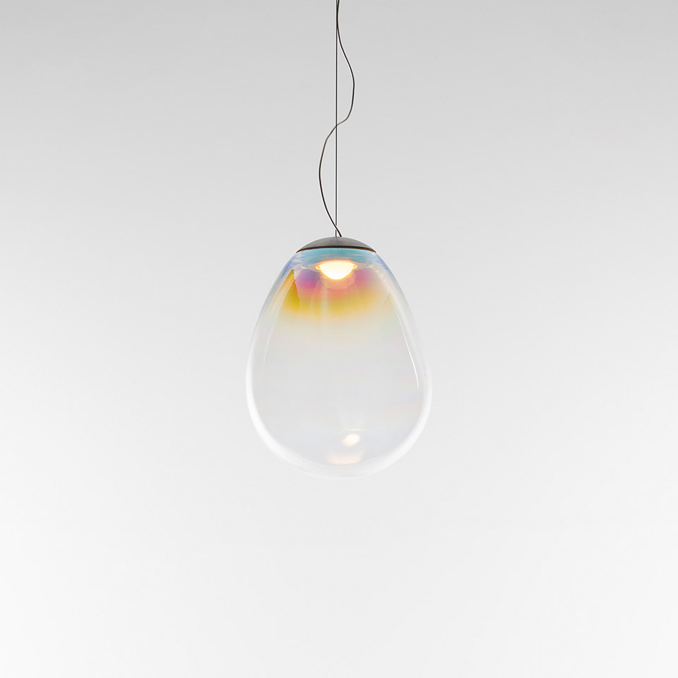 Artemide Stellar Nebula pendant lamp: teardrop-shaped transparent glass diffuser with iridescent pink and yellow hues, suspended by black cord