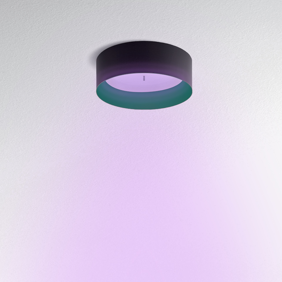 Tagora Soffitto 570 ceiling lamp by Artemide, dark cylindrical shade emitting soft purple ambient light downward