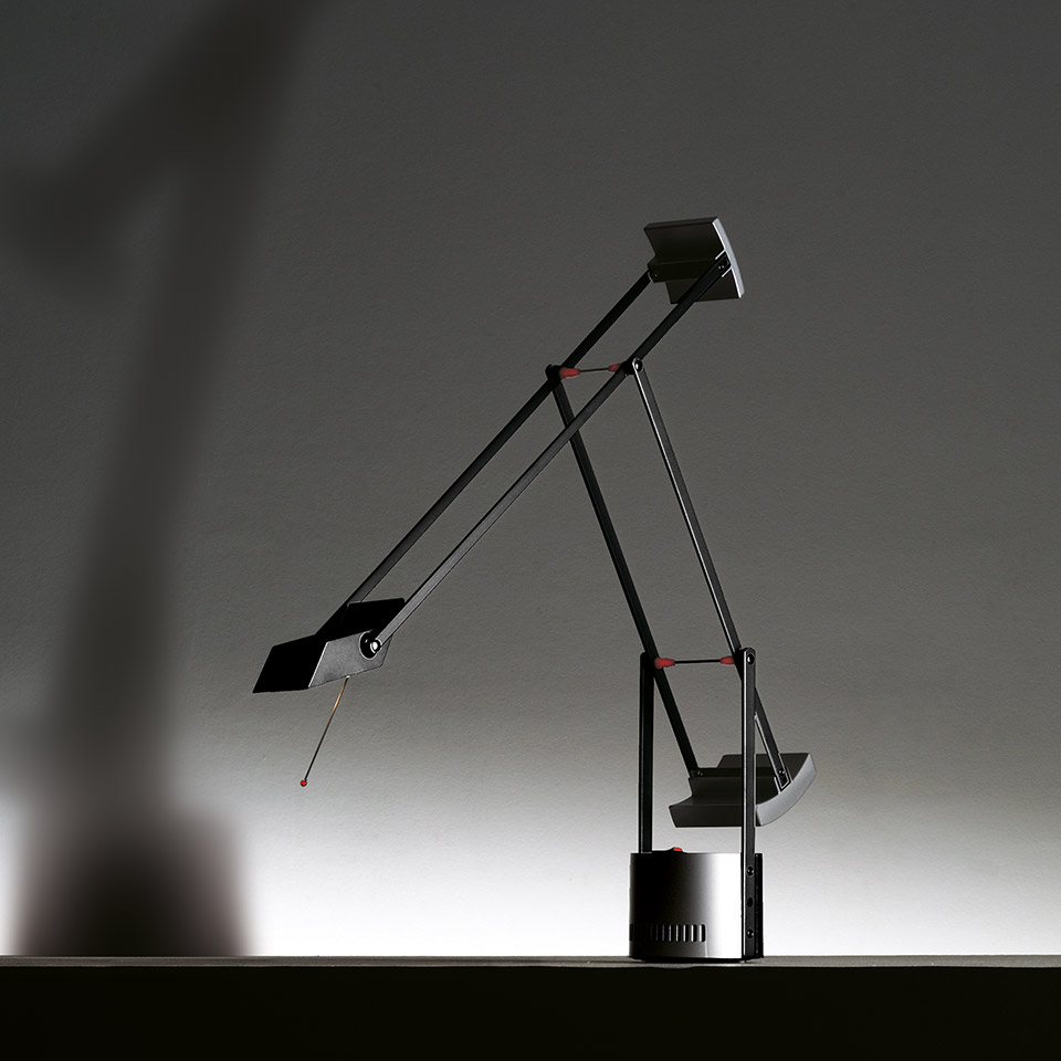 Artemide Tizio desk lamp in black, featuring iconic counterbalanced articulated arms with red accent joints on a cylindrical base