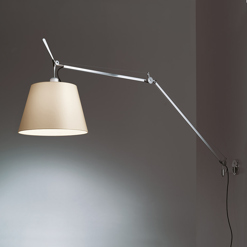 Artemide Tolomeo Mega Parete wall lamp with adjustable aluminum arm and beige fabric shade, mounted on a grey wall