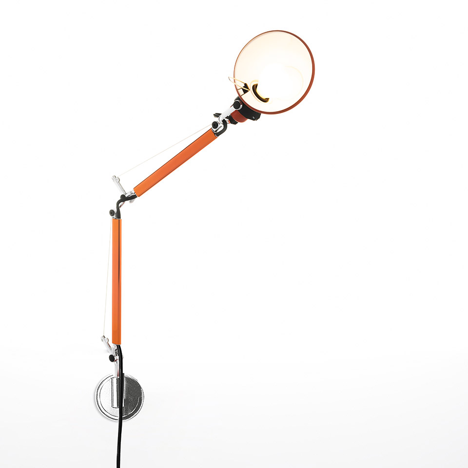 Artemide Tolomeo Micro Parete wall lamp in orange, with adjustable articulated arm and circular reflector shade, mounted on chrome wall bracket