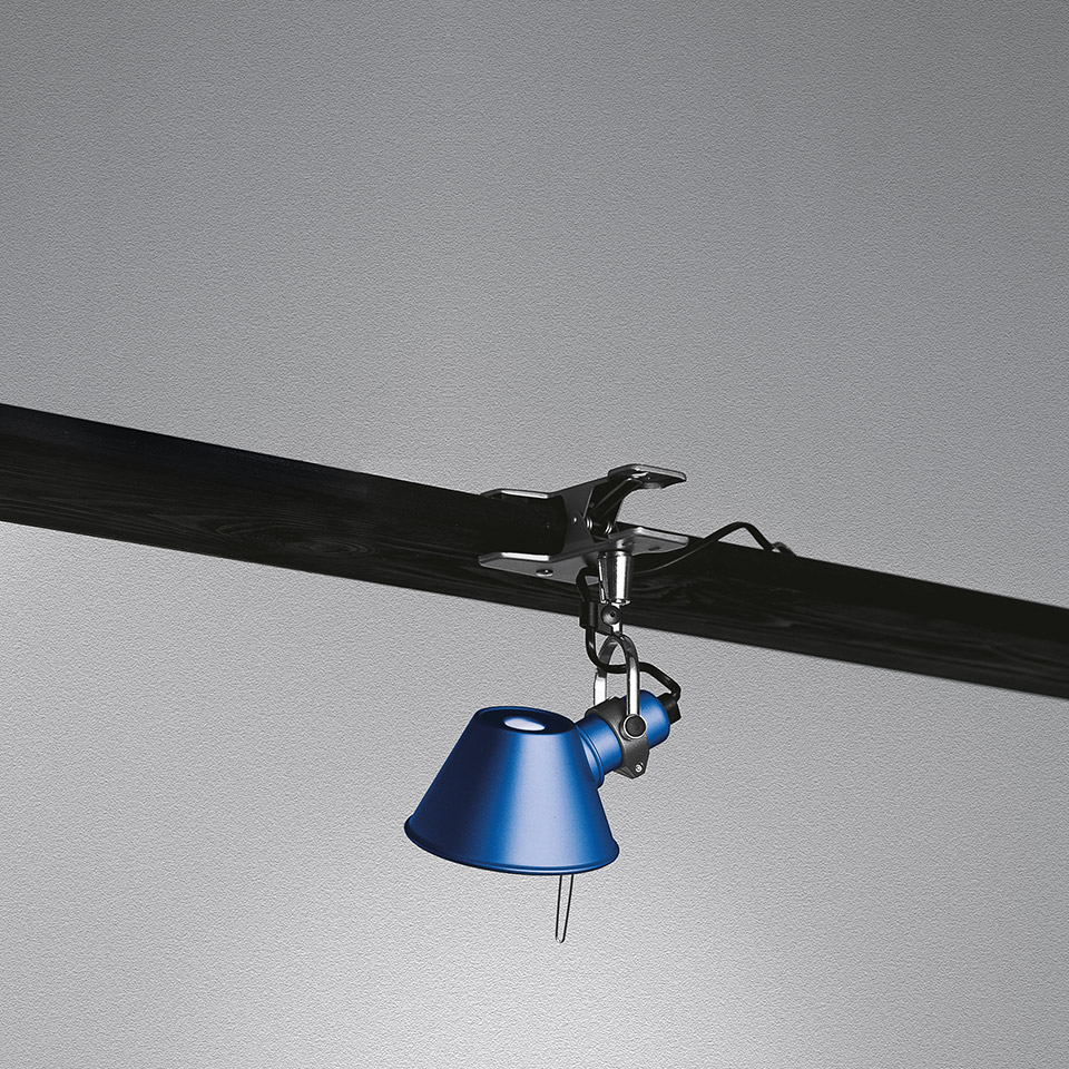 Artemide Tolomeo Pinza clip lamp in blue, clamped to a dark rail on ceiling, with adjustable conical shade
