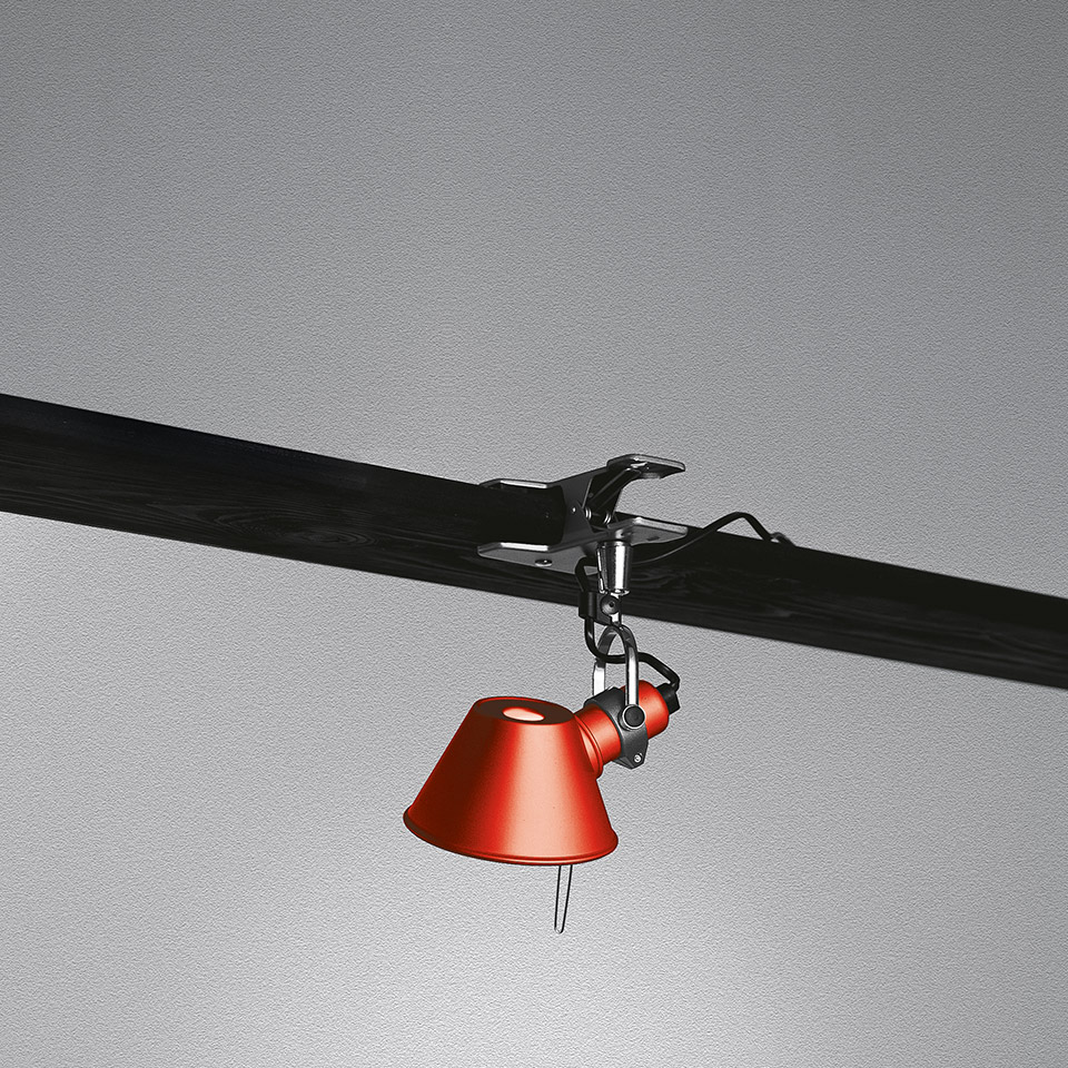 Artemide Tolomeo Pinza clip lamp with red conical shade, mounted on a dark horizontal rail via an adjustable metal clamp