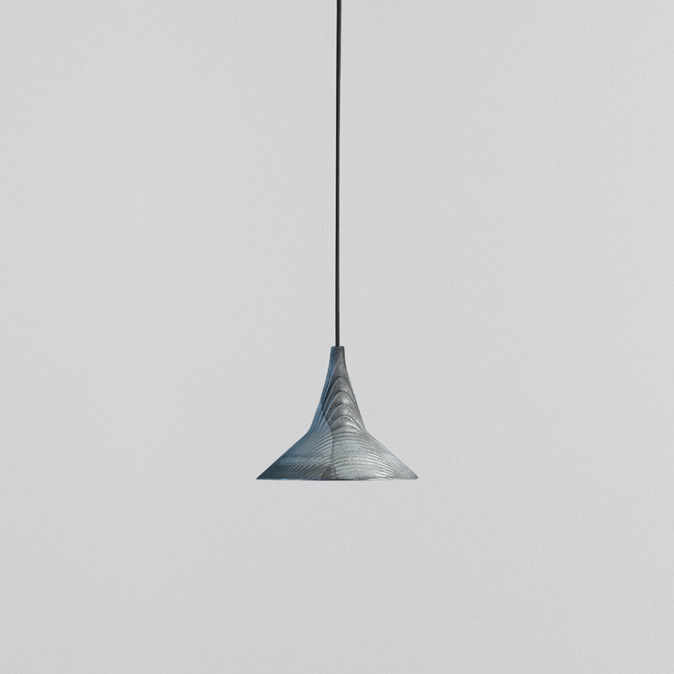 Artemide Turn Around pendant lamp with blue-grey textured conical shade featuring swirling pattern, suspended on a black cord