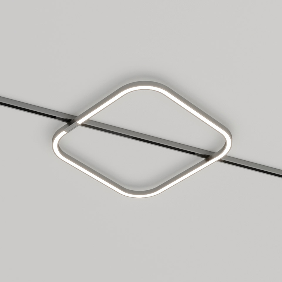 Artemide Turn Around System: square LED ceiling lamp with rounded corners, mounted diagonally on a ceiling track, emitting warm white light
