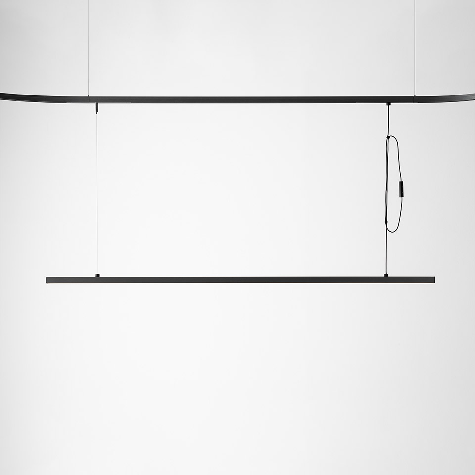 Artemide Turn Around System: slim black linear LED pendant suspended by thin cables from a curved ceiling rail with cable management