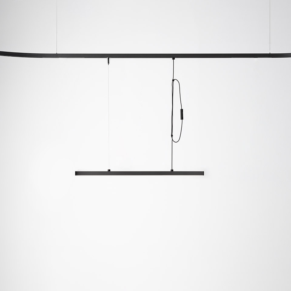 Artemide Turn Around System: slim black linear pendant lamp suspended from a ceiling track via thin cables and looped cord