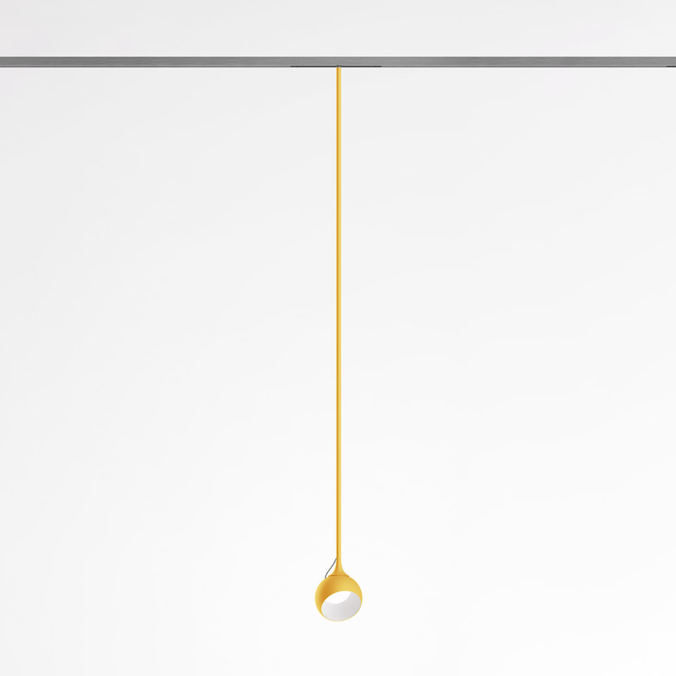 Artemide Turn Around System: yellow pendant lamp with slim stem and small tilted spherical head, mounted on ceiling track
