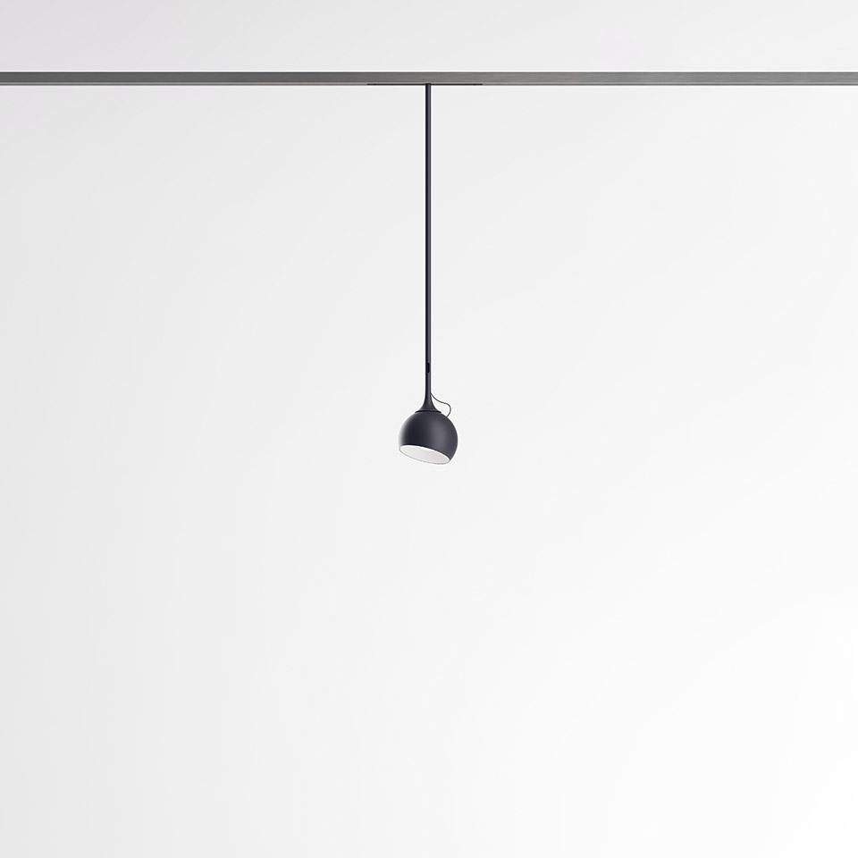 Artemide Turn Around System: small black dome pendant light hanging from a ceiling track via a thin black cable