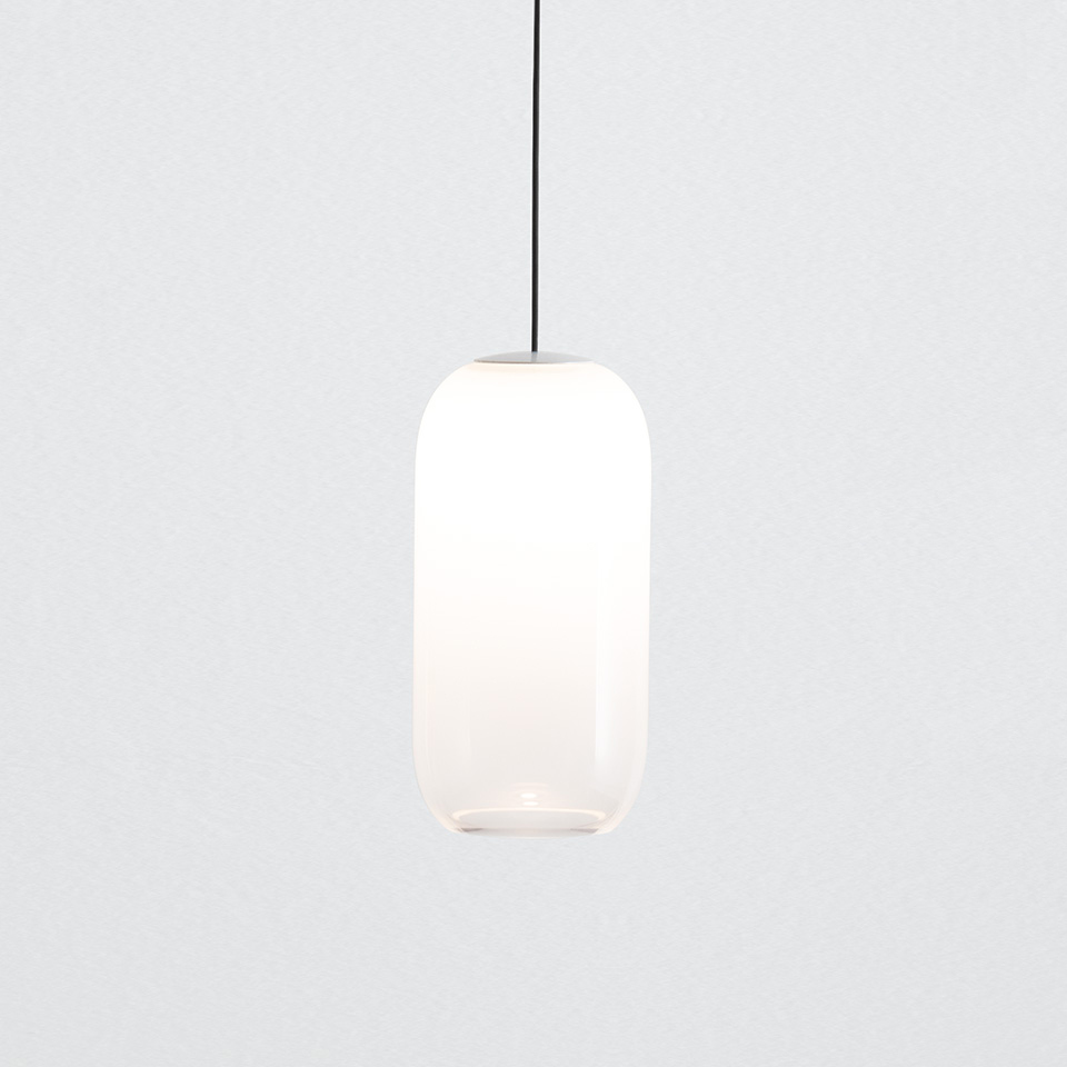 Artemide Turn Around pendant lamp with elongated oval opal white glass diffuser suspended by a black cord