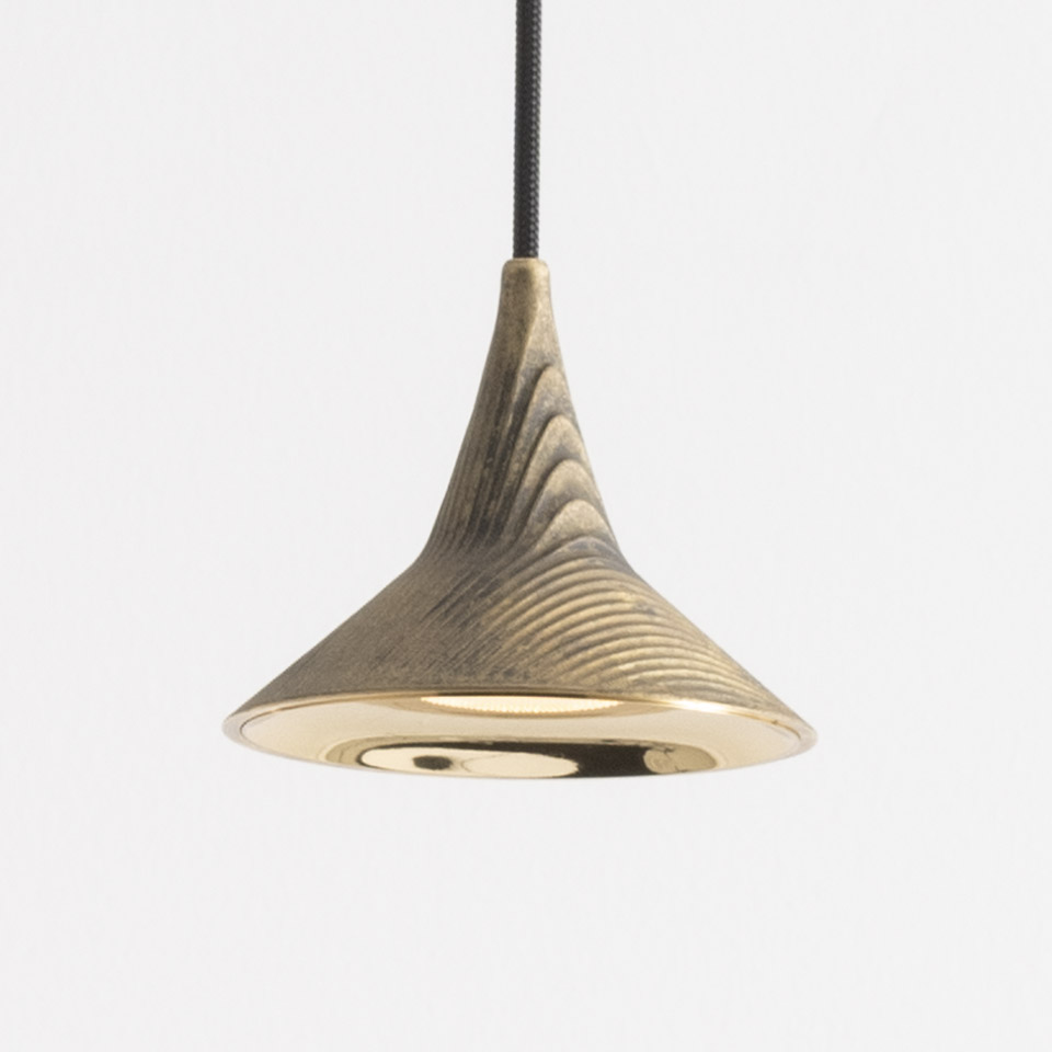 Artemide Unterlinden pendant lamp with flared brass shade featuring textured ridges, polished inner surface, suspended by black braided cord