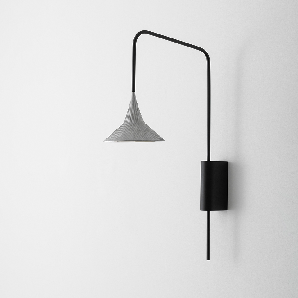 Artemide Unterlinden Outdoor wall lamp: black swing arm with cylindrical wall mount and downward conical textured silver shade