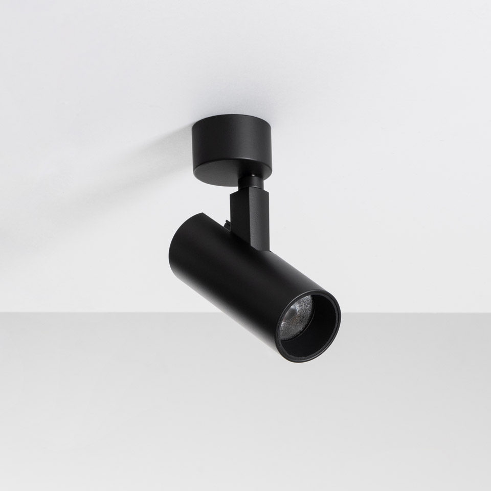 Artemide Vector Ceiling spotlight in matte black, adjustable cylindrical head mounted on ceiling base, directed at an angle
