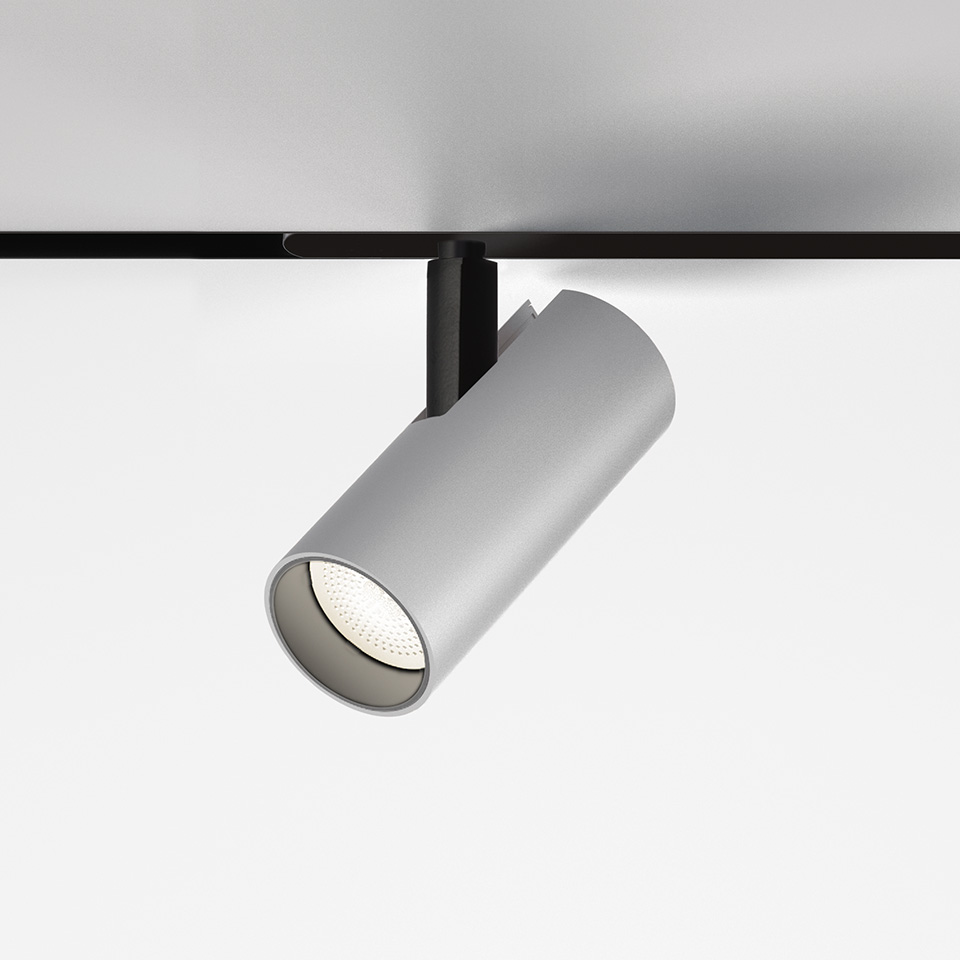 Artemide Vector Magnetic track spotlight: cylindrical grey LED head mounted on black magnetic track, tilted downward