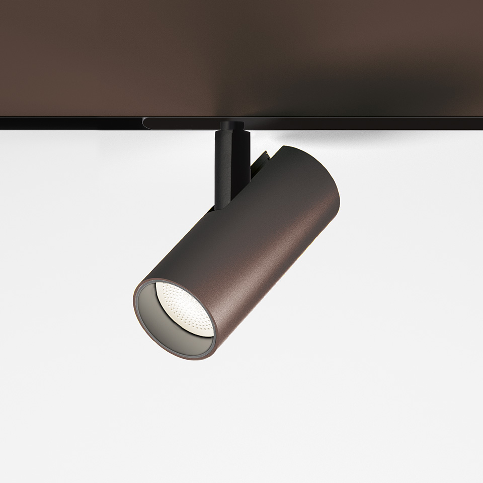 Artemide Vector Magnetic track spotlight in dark bronze, cylindrical body with LED lens, mounted on black magnetic track rail