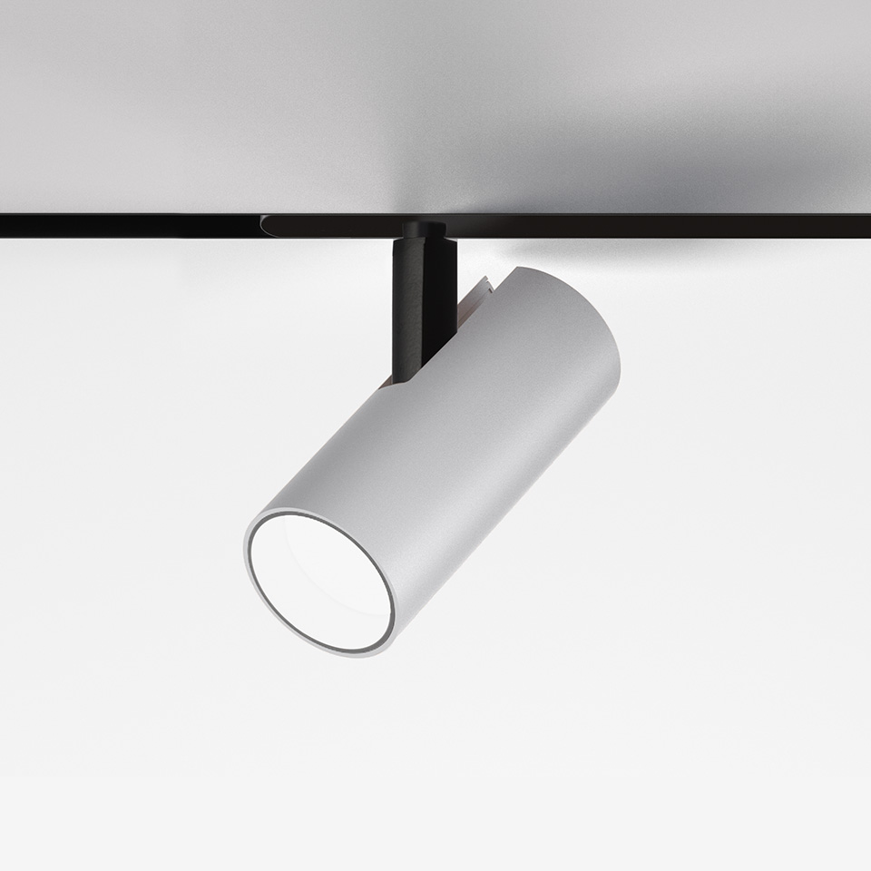 Artemide Vector Magnetic track spotlight: white cylindrical LED fixture mounted on black magnetic track, tilted downward
