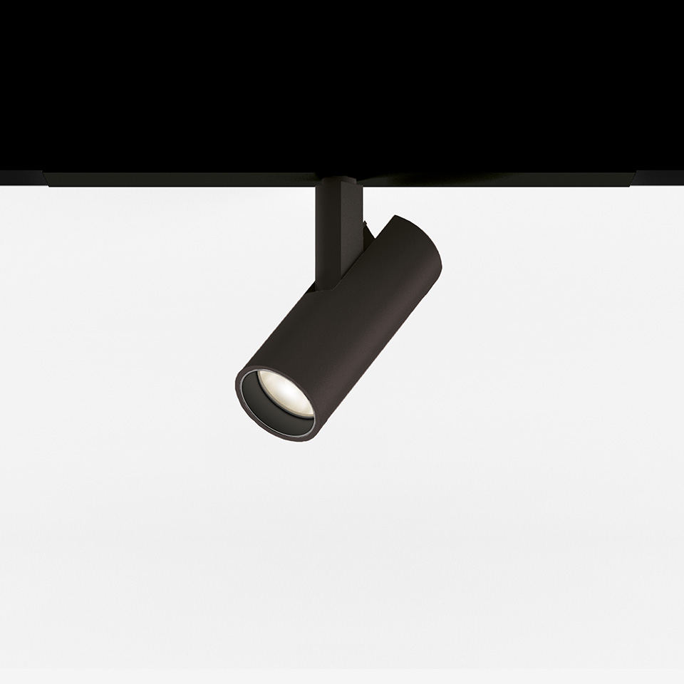 Artemide Vector Magnetic track spotlight in black, cylindrical head tilted at an angle, mounted on a magnetic track system
