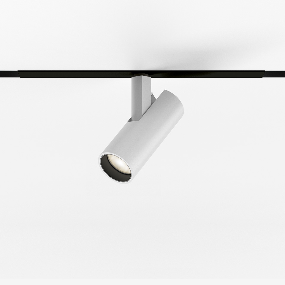 Artemide Vector Magnetic track spotlight in white, cylindrical body tilted on black magnetic track, with LED light source