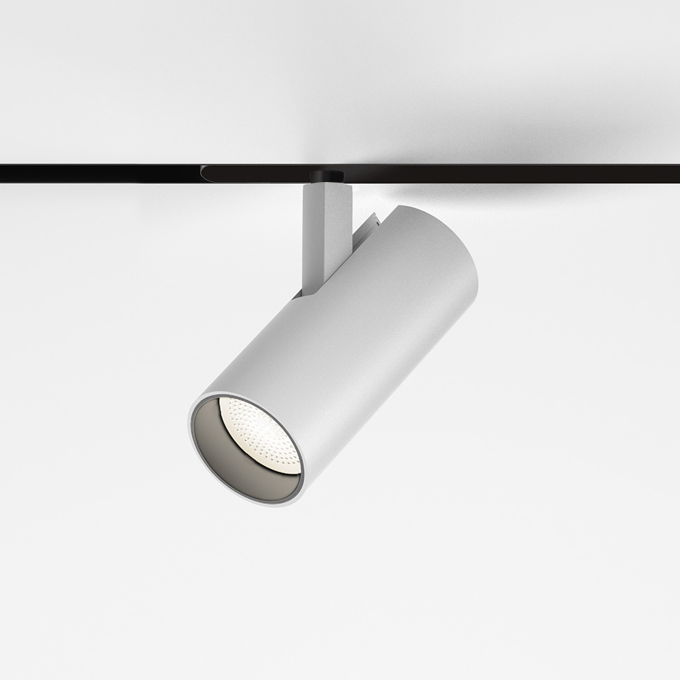 Artemide Vector Magnetic track spotlight in white, cylindrical body mounted on black magnetic track, adjustable directional LED head