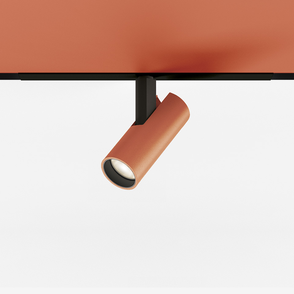 Artemide Vector Magnetic track spotlight in terracotta, cylindrical head on black mount, adjustable LED spot for magnetic track system