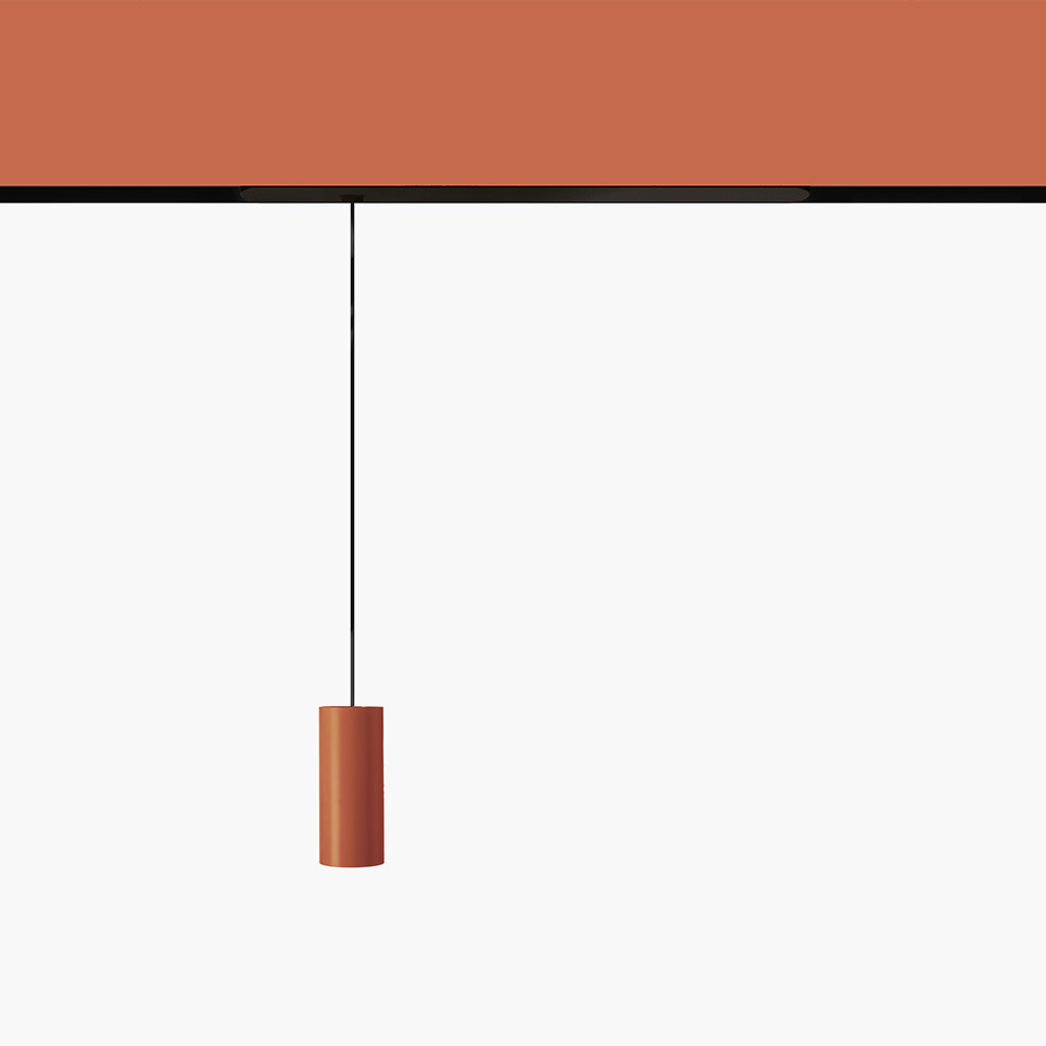 Artemide Vector Pendant Magnetic: terracotta cylindrical pendant lamp hanging from a black cord attached to a matching magnetic track.