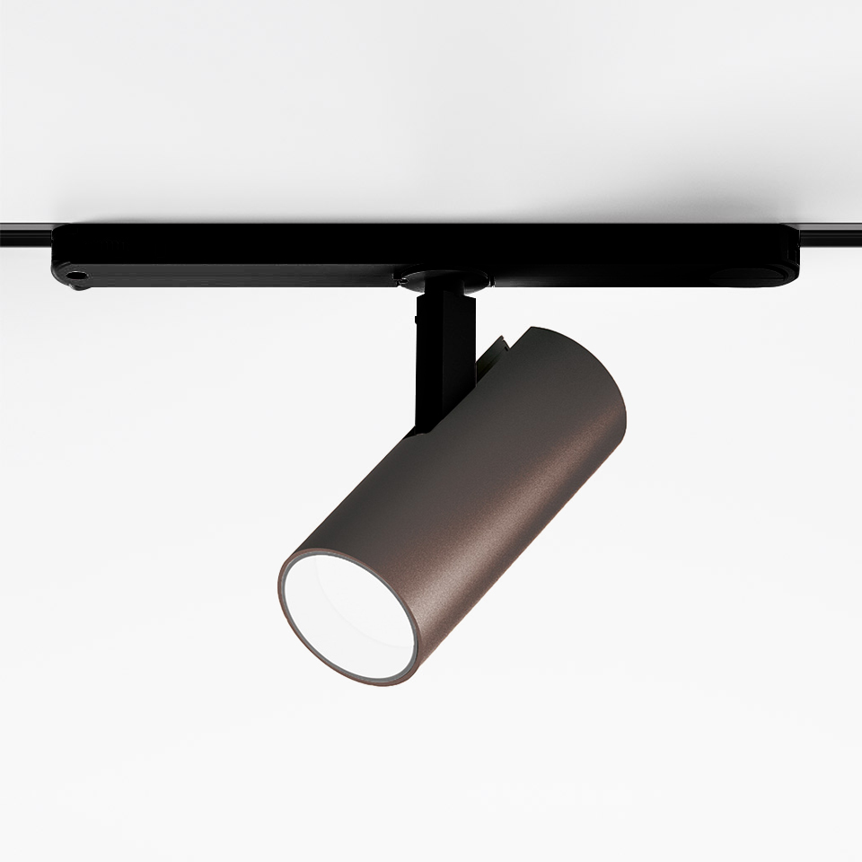 Artemide Vector Track 230V spotlight: bronze cylindrical LED head on black track mount, tilted downward for directional lighting