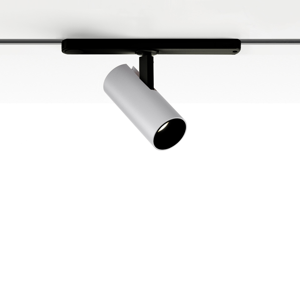 Artemide Vector Track 230V: white cylindrical adjustable spotlight mounted on a black track rail, tilted downward