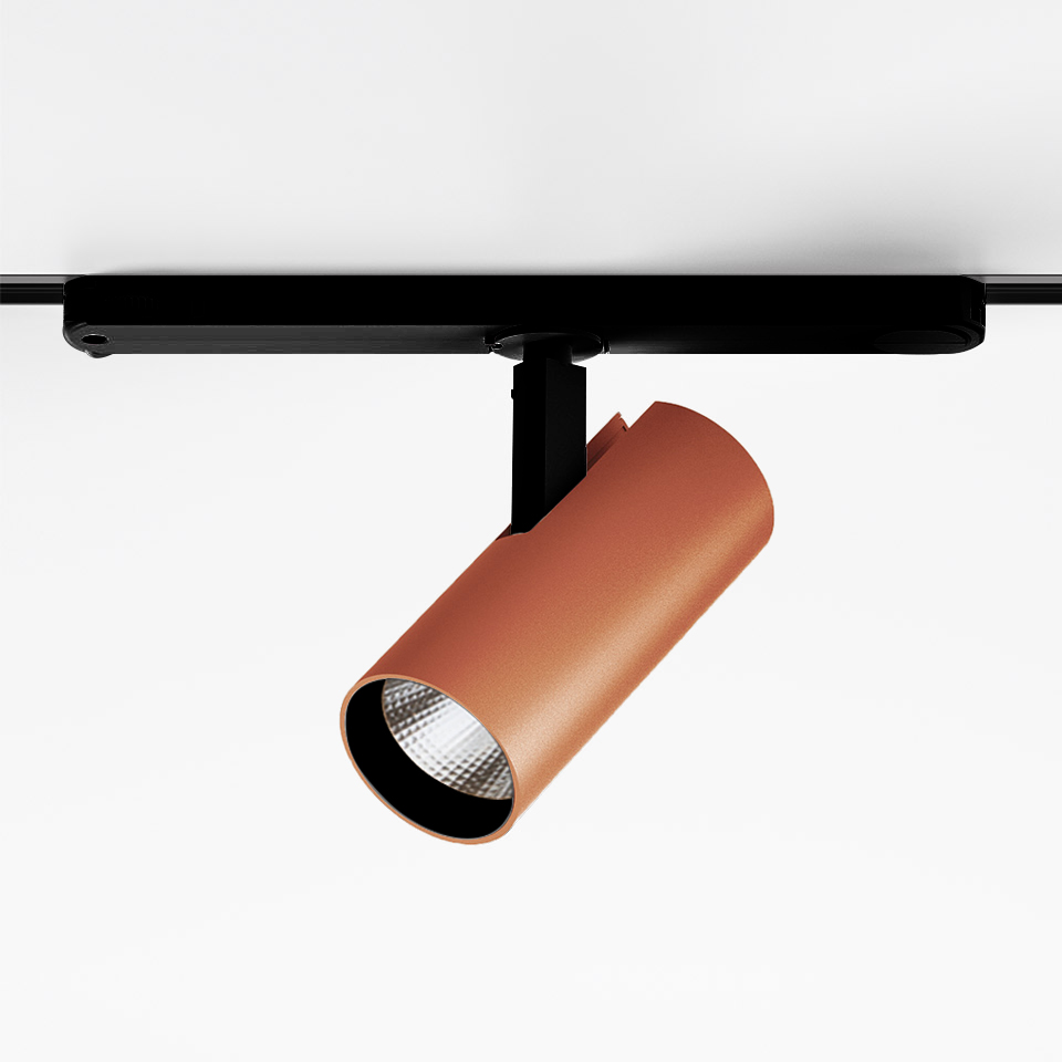 Artemide Vector Track 230V: terracotta cylindrical LED spotlight mounted on black track rail, adjustable head with faceted lens