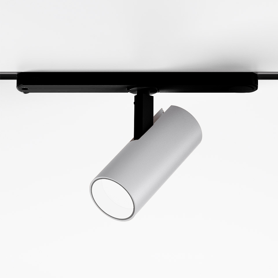 Artemide Vector Track 230V: white cylindrical adjustable spotlight mounted on a black track rail, tilted downward